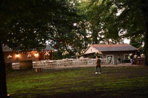 a man standing in a field in front of a house at OAK Glamping Relax in Manziana