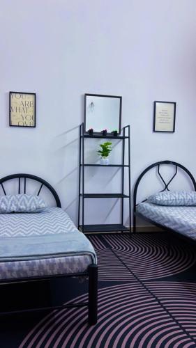 a room with two beds and a book shelf at Arrafah Homestay Klebang in Tranquerah