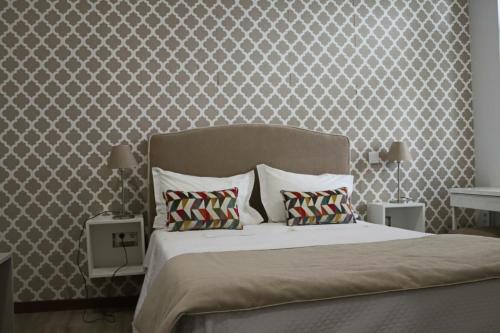 a bedroom with a large bed with two pillows at Cagaréus in Aveiro