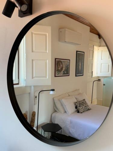 a mirror reflecting a bedroom with a bed at Galeria 99 in Porto