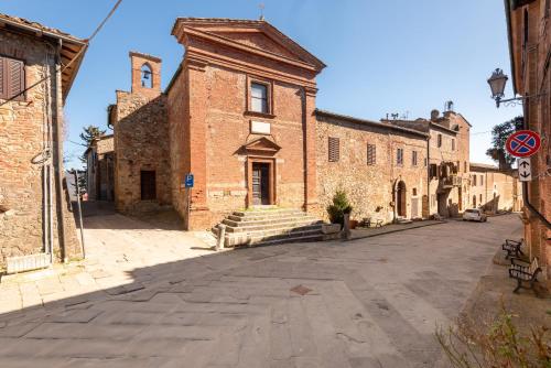 an old brick building with a tower on a street at Traveling_spoon in Belforte