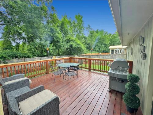 a deck with a grill and a table and chairs at Fayetteville Getaway in Fayetteville