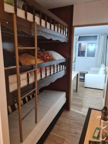 Armazan156 studio في سانت لاري سولون: غرفة بها سريران بطابقين وغرفة معيشة