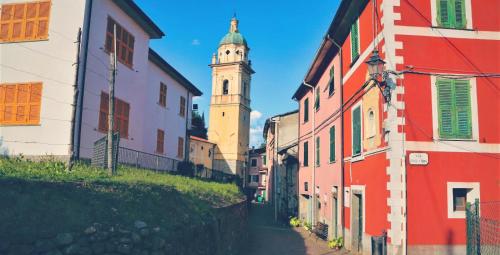 ピニョーネにあるCasetta Rosaの背景に時計塔がある狭い路地