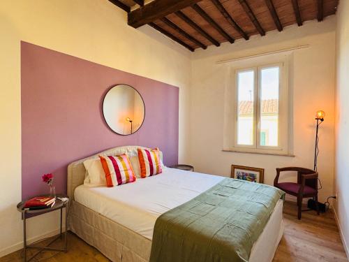 a bedroom with a bed and a mirror on the wall at Santa Maria Dreaming Rooftop in Pisa