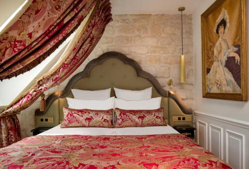 a bedroom with a large bed with a red bedspread at Hôtel Kleber Paris & Spa in Paris