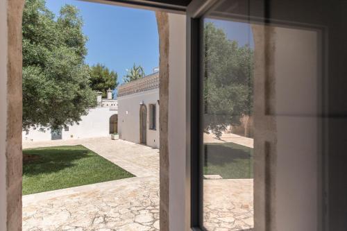 a view of a yard from a window of a house at Masseria San Giovanni - Epoca Collection in Fasano