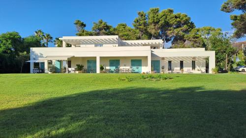 a large white house with a large yard at Villa Agapanto in Paestum