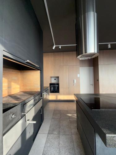 a large kitchen with a black counter top and appliances at Depto moderno con vista al mar in El Cerrillo