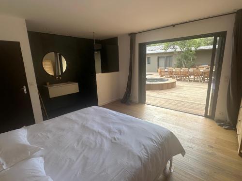 una camera con un letto e una grande porta scorrevole in vetro di Villa Toussaint a Pianottoli-Caldarello