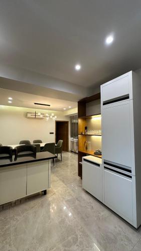 a living room with chairs and a large refrigerator at Woodlands Apartment- Fully furnished Luxury Apt in Jodhpur