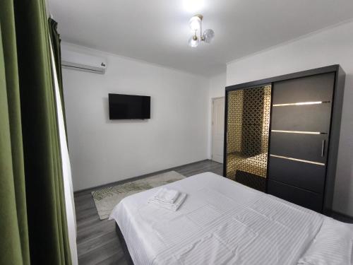 a bedroom with a bed and a tv on the wall at 11IunieResidence in Târgu Jiu
