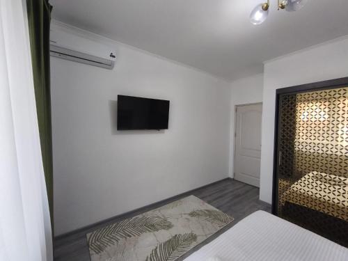 a room with a bed and a tv on a wall at 11IunieResidence in Târgu Jiu