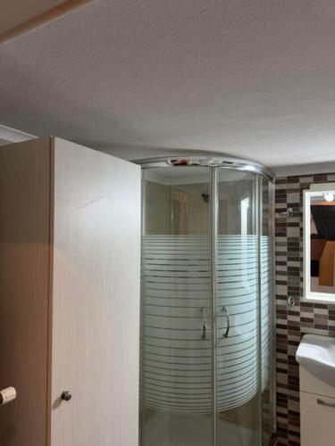 a bathroom with a glass shower with a sink at Almeta Apartment 3 in Chios