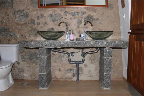 a stone bathroom with two sinks and a toilet at Horta Do Zé Miguel in Monchique