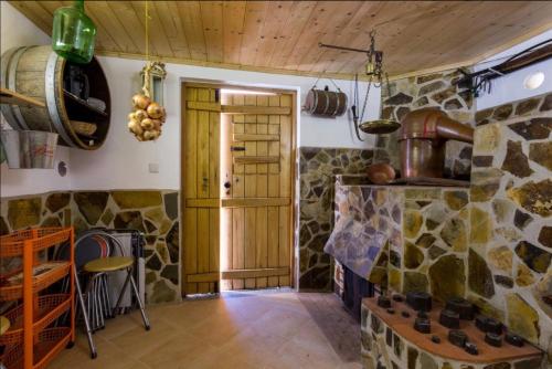 a kitchen with a stone fireplace and a wooden door at Horta Do Zé Miguel in Monchique