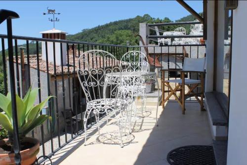 a balcony with white chairs and tables on a railing at Horta Do Zé Miguel in Monchique