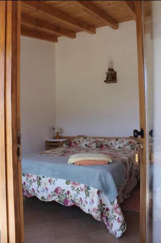 a bedroom with a bed with a blanket on it at Horta Do Zé Miguel in Monchique