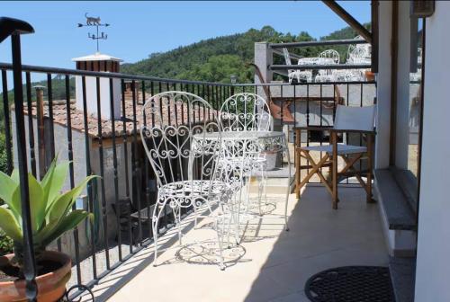 a balcony with white chairs and tables on a railing at Horta Do Zé Miguel in Monchique