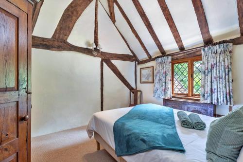 a bedroom with a bed and a window at Finest Retreats - Sandhill Cottage with hot tub in Turners Hill