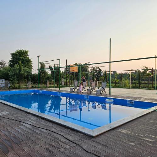 a swimming pool with chairs and a basketball court at Iveria Parky and cottages in Shekvetili