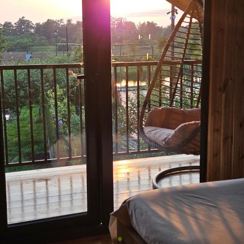 a room with a view of a balcony with a bed at Iveria Parky and cottages in Shekvetili