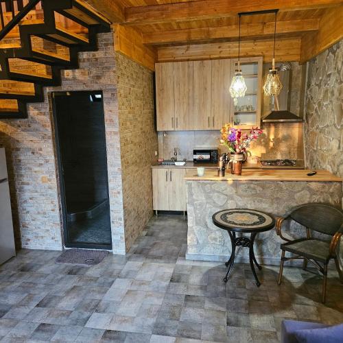 a kitchen with a counter and a table with chairs at Iveria Parky and cottages in Shekvetili