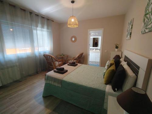 a bedroom with a bed and a table and chairs at Lembranzas in Padrón