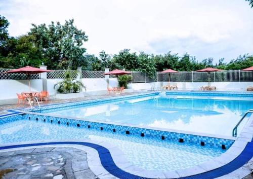 a large swimming pool with chairs and umbrellas at Siritamu Resort & Spa in Bungoma
