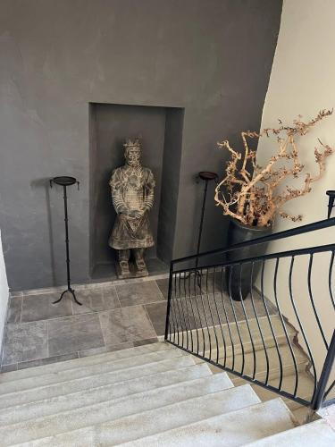a statue of a man on a wall next to a staircase at Luxury authentic private villa with private swimming pool in Monte Colombo