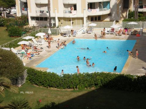un groupe de personnes dans une grande piscine dans l'établissement Fréjus le Césarée location de vacances Parking Piscine Terrasse Wifi, à Fréjus