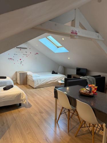 une chambre mansardée avec deux lits et une table dans l'établissement Elysium Lodges, à Amnéville