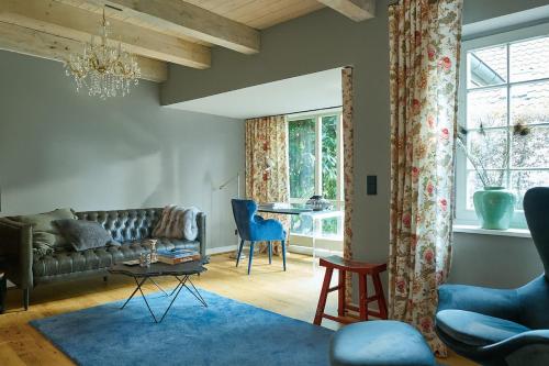 a living room with a couch and a table at Landhaus Jenischpark in Hamburg