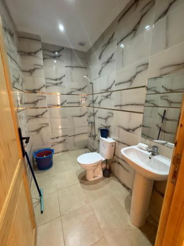 a bathroom with a toilet and a sink at Houssam immobilier 7 in Souira Guedima