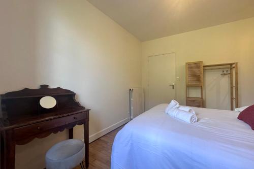 a bedroom with a bed and a table and a mirror at Maison de la Fontaine - Typique - Bourg de Collonges in Collonges la rouge