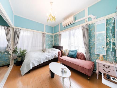 a bedroom with a bed and a couch and a table at Shinjuku Area , 3min walk to Nishi-Shinjuku 5-chome, 3min to Shinjuku, Switch, Free Wi-Fi , PocketWi-Fi in Tokyo