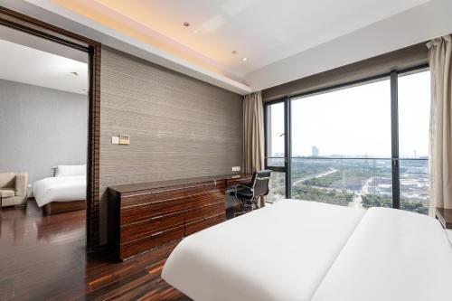 a hotel room with a bed and a large window at Snug Gaokong Jiangjing Hotel in Guangzhou