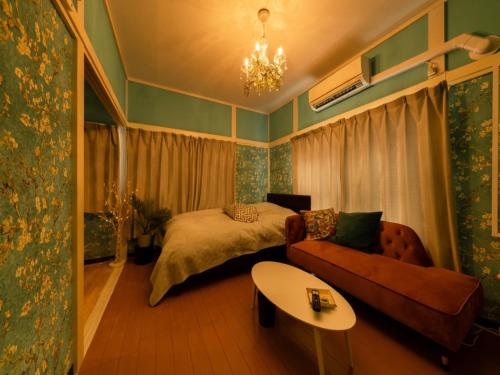 a bedroom with a bed and a couch and a table at Shinjuku, 3min walk from Nishi-Shinjuku 5-chome Sta, 3min Shinjuku Sta Switch, Wi-Fi ,Pocketwi-Fi in Tokyo