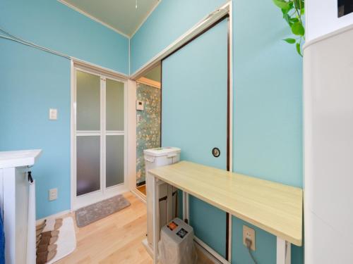 a home office with blue walls and a wooden desk at Shinjuku, 3min walk from Nishi-Shinjuku 5-chome Sta, 3min Shinjuku Sta Switch, Wi-Fi ,Pocketwi-Fi in Tokyo