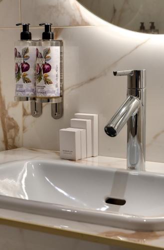 a bathroom sink with a faucet and a mirror at Hôtel Kleber Paris & Spa in Paris