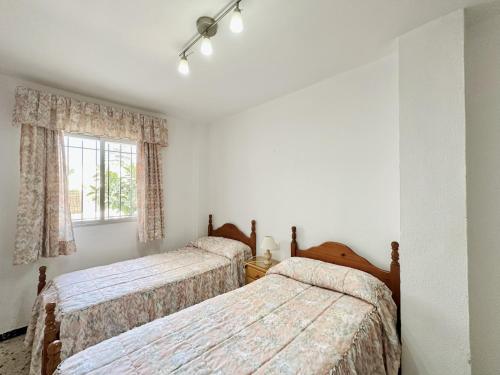 a bedroom with two beds and a window at Apartamentos Turísticos Santo Rostro in Chipiona