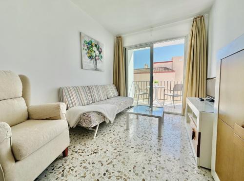 a living room with a couch and a tv at Apartamentos Turísticos Santo Rostro in Chipiona