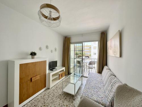 a living room with a couch and a tv at Apartamentos Turísticos Santo Rostro in Chipiona