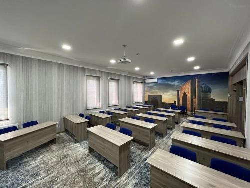 a classroom with rows of desks and blue chairs at Mansion Hotel in Stantsiya Kyzyl-Tukumachi