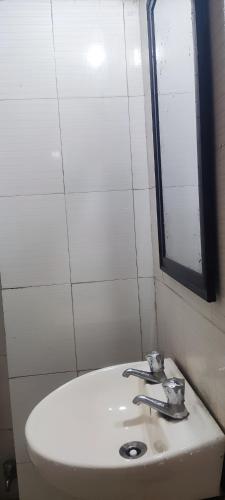 a bathroom with a white sink and a mirror at Hotel Ishaan International Near Yatra Parchi Counter in Katra