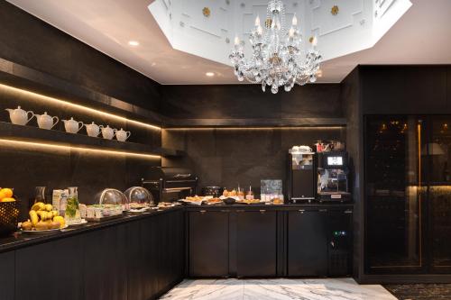 a restaurant with a buffet with a chandelier at Hôtel Kleber Paris & Spa in Paris