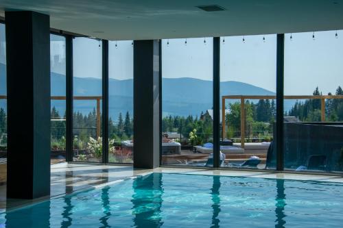 a swimming pool in a house with windows at ШПИЦІ Hotel & SPA in Bukovel