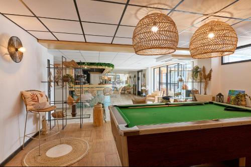 a living room with a pool table in it at Hôtel Les Sables - Urban Style - by Logis Hotels in Canet-en-Roussillon