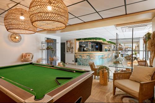 a billiard room with a pool table and a bar at Hôtel Les Sables - Urban Style - by Logis Hotels in Canet-en-Roussillon