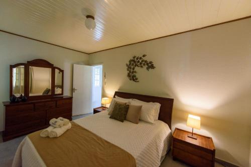a bedroom with a bed with a teddy bear on it at Minha Glória Hotel Boutique in Bom Jardim